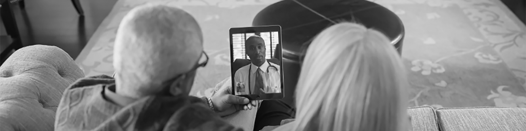 couple speaking with doctor on a tablet device